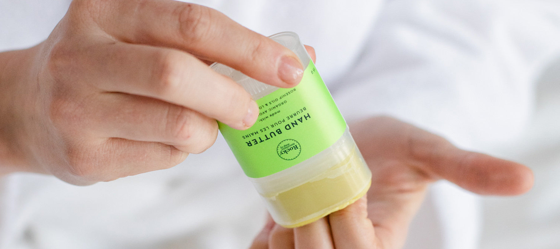 Image of hands rubbing moisturizing organic hand butter onto cuticles.