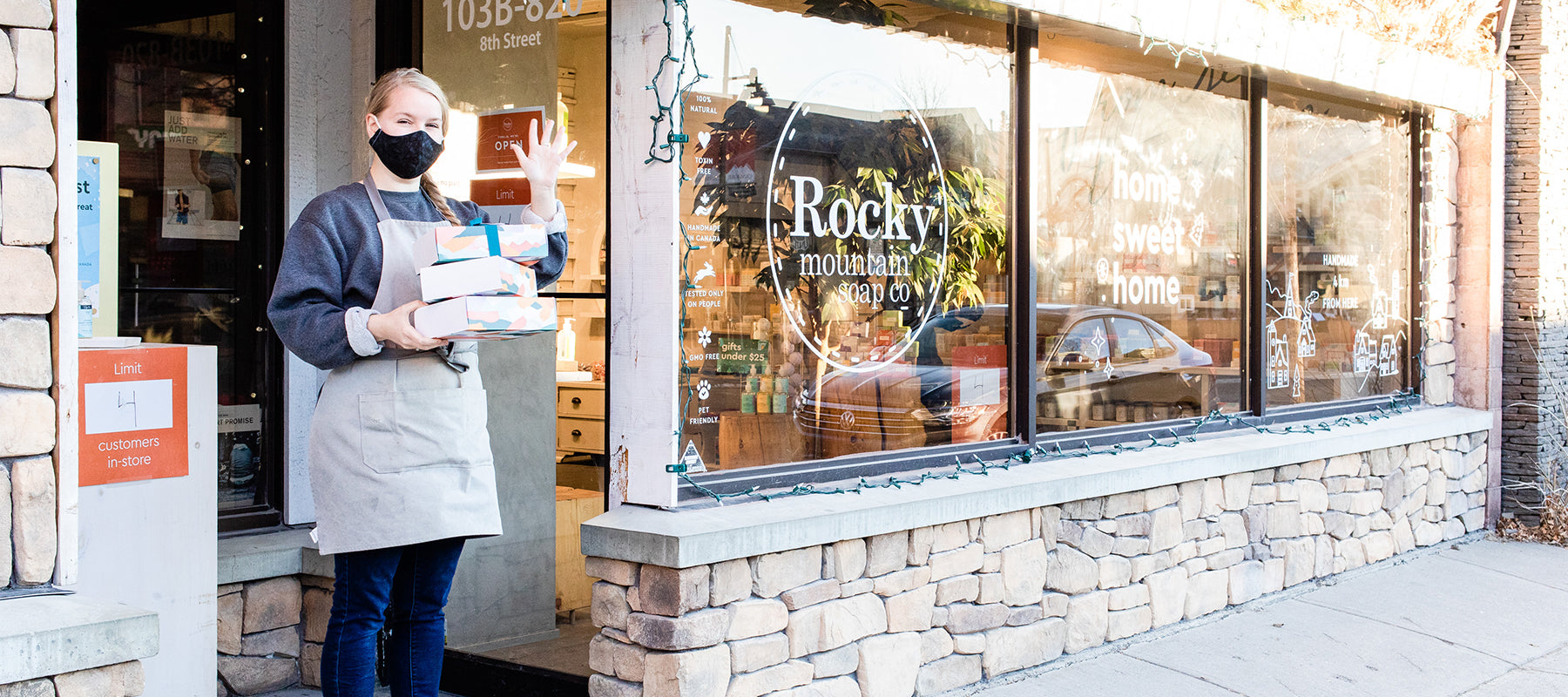 Rocky Mountain Soap Company employee waving in front of the store in Canmore, Alberta. 
