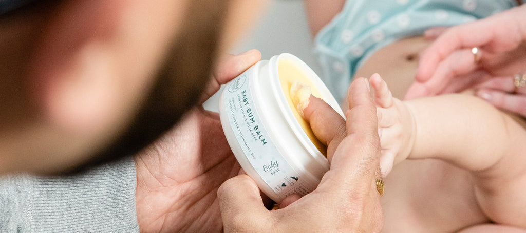 person applying bum balm to baby