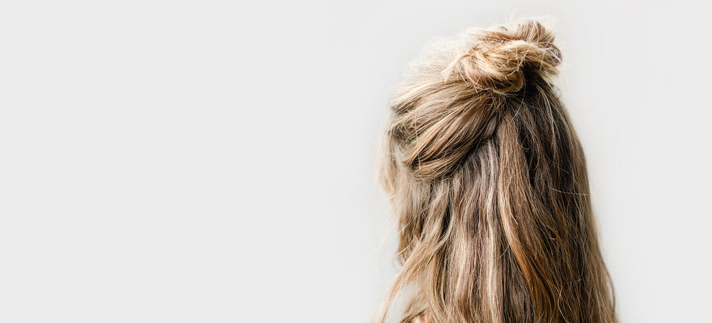 Hair tousled and half up in chic messy top knot as part of rocky Mountain Soap Company's hassle-free holiday hairstyle guide.