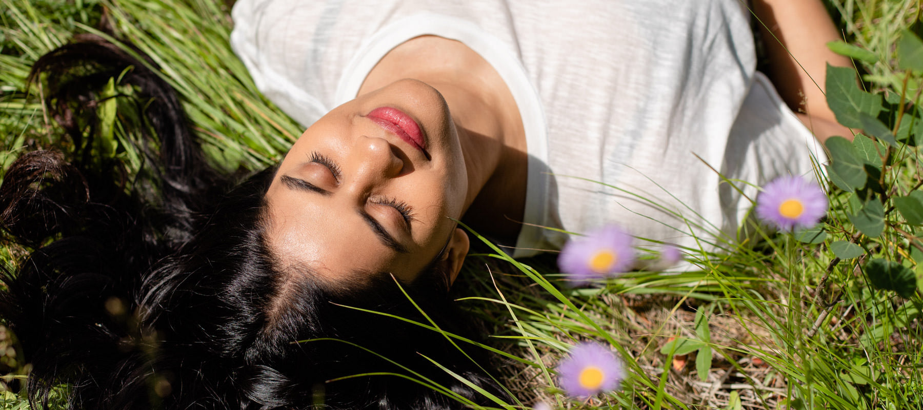 woman lying in the grass and wildflowers. 