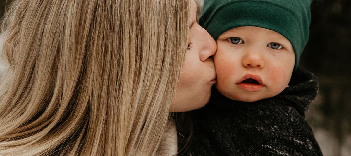 picture of mother kissing baby's cheek.