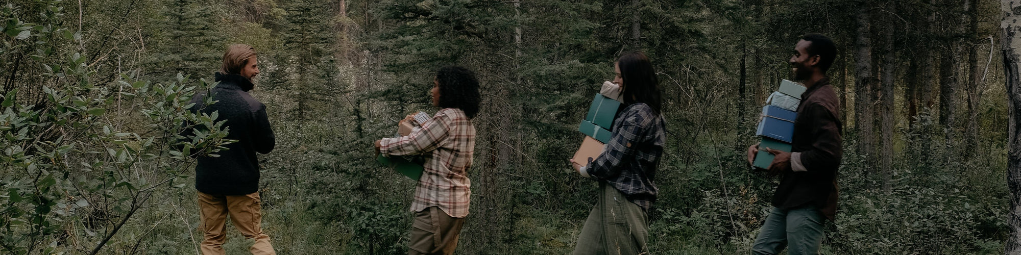 four people walking through the woods with gifts