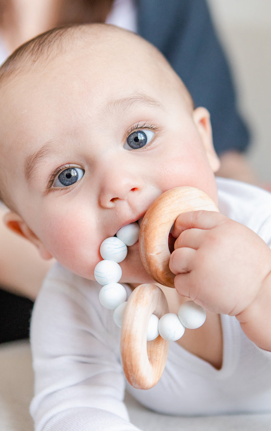 closeup photo of a baby chewing on a toy