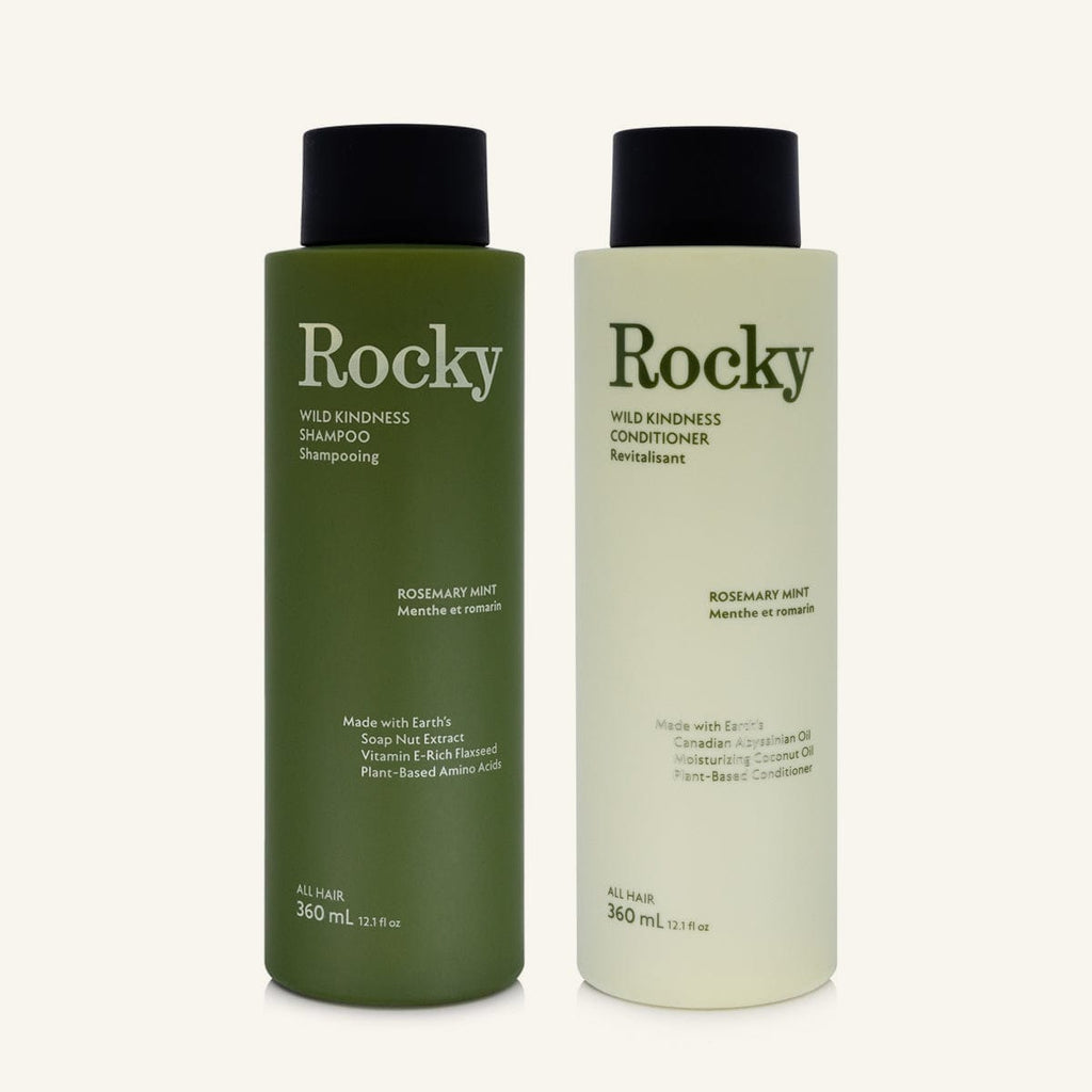 Two 360ml bottles of Rocky Wild Kindness Shampoo and Conditioner in rosemary mint for normal hair, featuring a olive green bottles with black caps, centered on a light cream background.