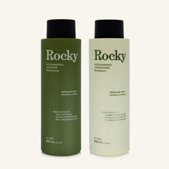 Two 360ml bottles of Rocky Wild Kindness Shampoo and Conditioner in rosemary mint for normal hair, featuring a olive green bottles with black caps, centered on a light cream background.