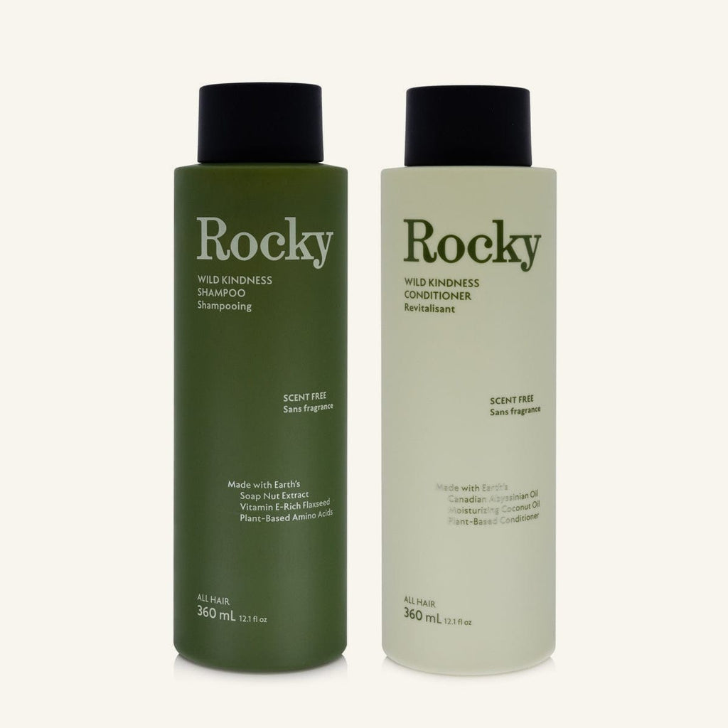 Two 360ml bottles of Rocky Wild Kindness Shampoo and Conditioner in scent free for normal hair, featuring a olive green bottles with black caps, centered on a light cream background.