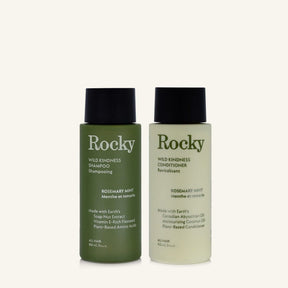 Two 90ml bottles of Rocky Wild Kindness Shampoo and Conditioner in rosemary mint for normal hair, featuring a olive green bottles with black caps, centered on a light cream background.
