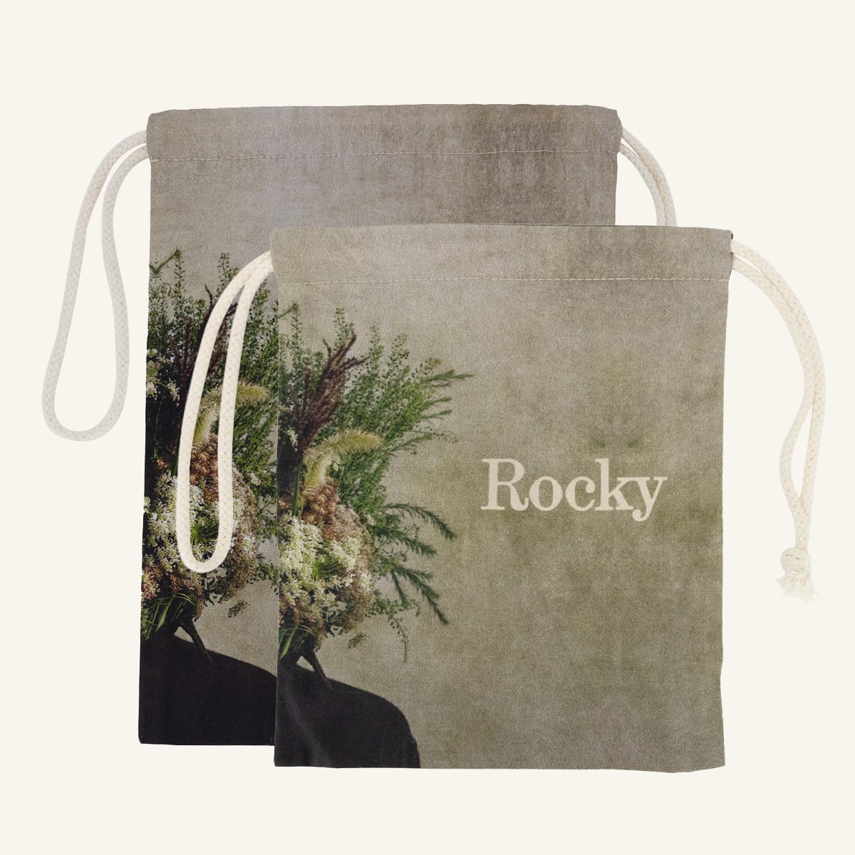 Large and small drawstring bags with floral design and 'Rocky' branding on a beige background