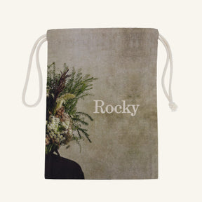 Large drawstring bag with floral design and 'Rocky' branding on a beige background