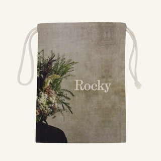 Large drawstring bag with floral design and 'Rocky' branding on a beige background