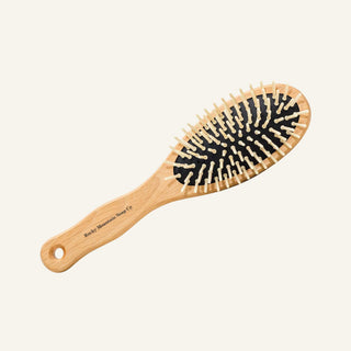 A 9 inch wooden hairbrush with a light natural wood handle and bristles, set against a solid off-white background.