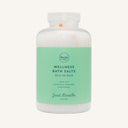 A clear plastic bottle of Just Breathe Wellness Bath Salts filled with white bath salts and a green label featuring aromatic eucalyptus, rosemary, and peppermint.