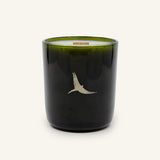 Moonlight Candle in a dark green glass vessel with a gold bird illustration and a wooden wick.