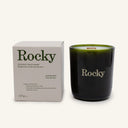 A Rocky Mountain Soap Company Moonlight Candle in a dark green glass jar next to its box, both labeled with scent and ingredient details in English and French.
