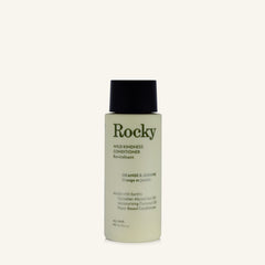 A 90ml bottle of Rocky Wild Kindness Conditioner in Orange & Jasmine scent, featuring a pale yellow-green bottle and a black cap, set against a solid off-white background.