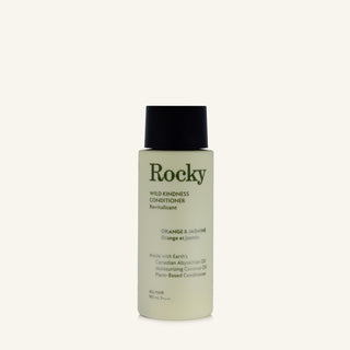 A 90ml bottle of Rocky Wild Kindness Conditioner in Orange & Jasmine scent, featuring a pale yellow-green bottle and a black cap, set against a solid off-white background.