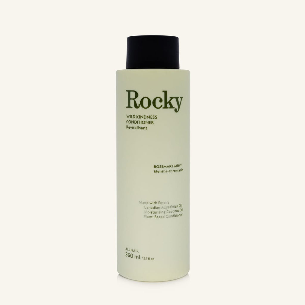 A 360 ml bottle of Rocky Wild Kindess Conditioner in Rosemary Mint, featuring a pale sage green bottle and a black cap, set against a solid off-white background.