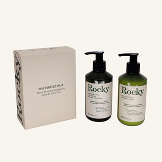 The Perfect Pair gift set in Blood Orange & Grapefruit scent featuring a beige box and two pump bottles (Rocky everything wash and oat body lotion) in black and green, on a light cream background.