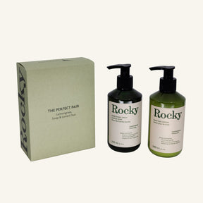 The Perfect Pair gift set in lemongrass scent featuring a beige box and two pump bottles (Rocky everything wash and oat body lotion) in black and green, on a light cream background.