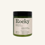 A dark green jar of Rocky Mountain Soap Company Vanilla Coconut Sugar Scrub with a black lid and a cream-colored label detailing product ingredients and volume.