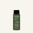 A 90ml bottle of Rocky Wild Kindness Shampoo in Rosemary Mint for normal hair, featuring an olive green bottle and a black cap, centered on a light cream background.