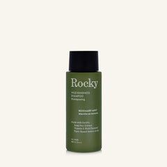 A 90ml bottle of Rocky Wild Kindness Shampoo in Rosemary Mint for normal hair, featuring an olive green bottle and a black cap, centered on a light cream background.