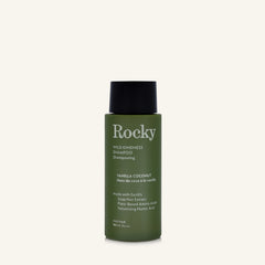 A 90ml bottle of Rocky Wild Kindness Shampoo in Vanilla Coconut for fine hair, featuring an olive green bottle and a black cap, centered on a light cream background.