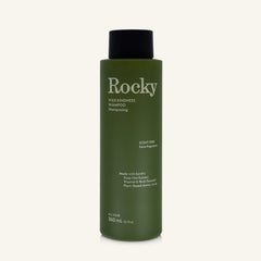 A 360ml bottle of Rocky Wild Kindness Shampoo in scent free for normal hair, featuring an olive green bottle and a black cap, centered on a light cream background.