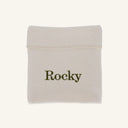 A small off-white fabric pouch with the name 'Rocky' printed in dark olive green text, shown on a plain light beige background.