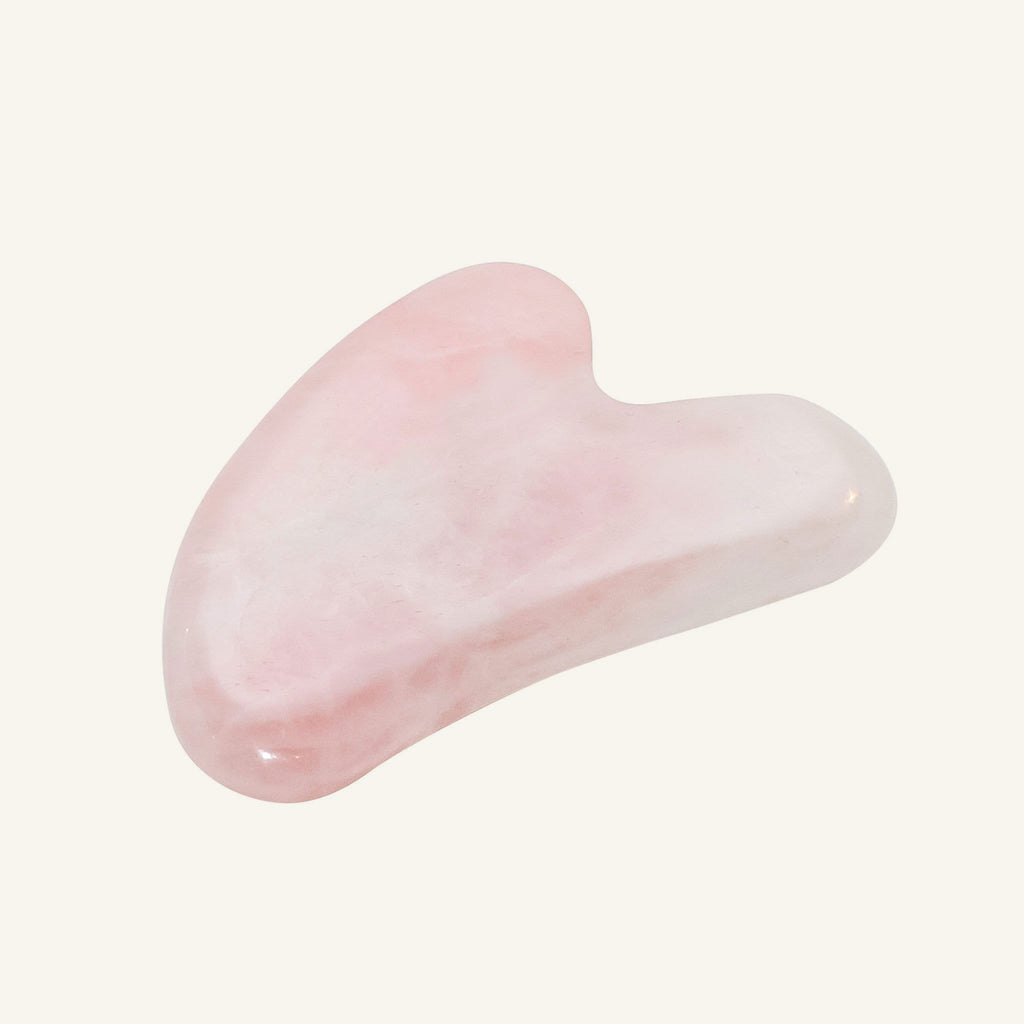 A polished pink rose quartz gua sha massage tool