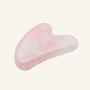 A polished pink rose quartz gua sha massage tool