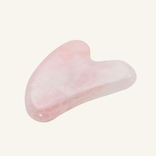 A polished pink rose quartz gua sha massage tool