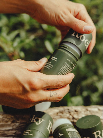 Hands holding a tube of Tea Tree Natural Deodorant