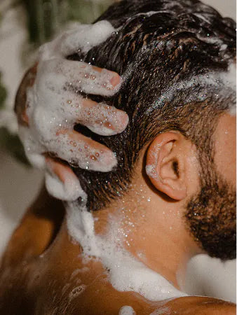 A man washing his hair with a Hair Bar