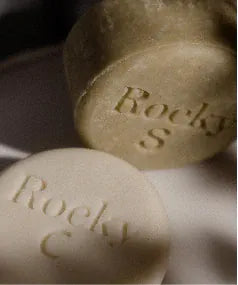 A shampoo bar and a conditioner bar, stamped Rocky