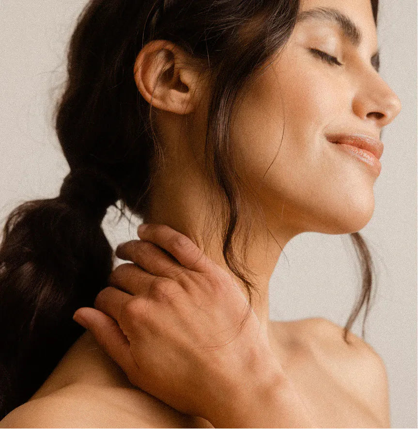 A woman with her hand at her neck, eyes closed