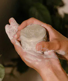 A lathered Hair Bar held in two hands